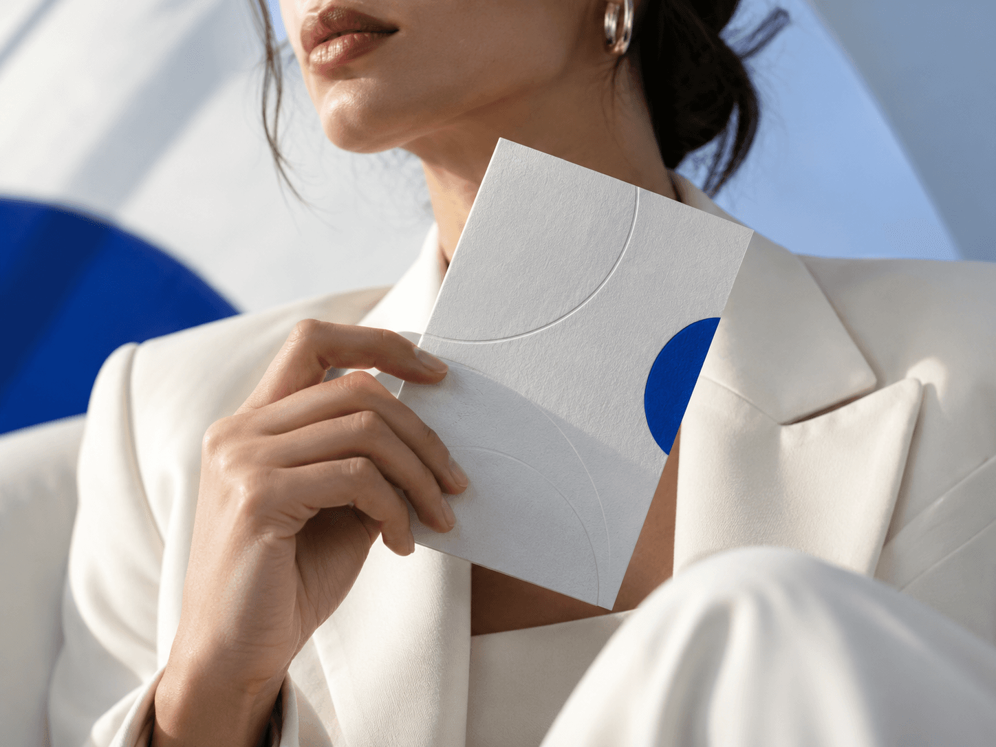 Hand holding a branded card with a blue accent
